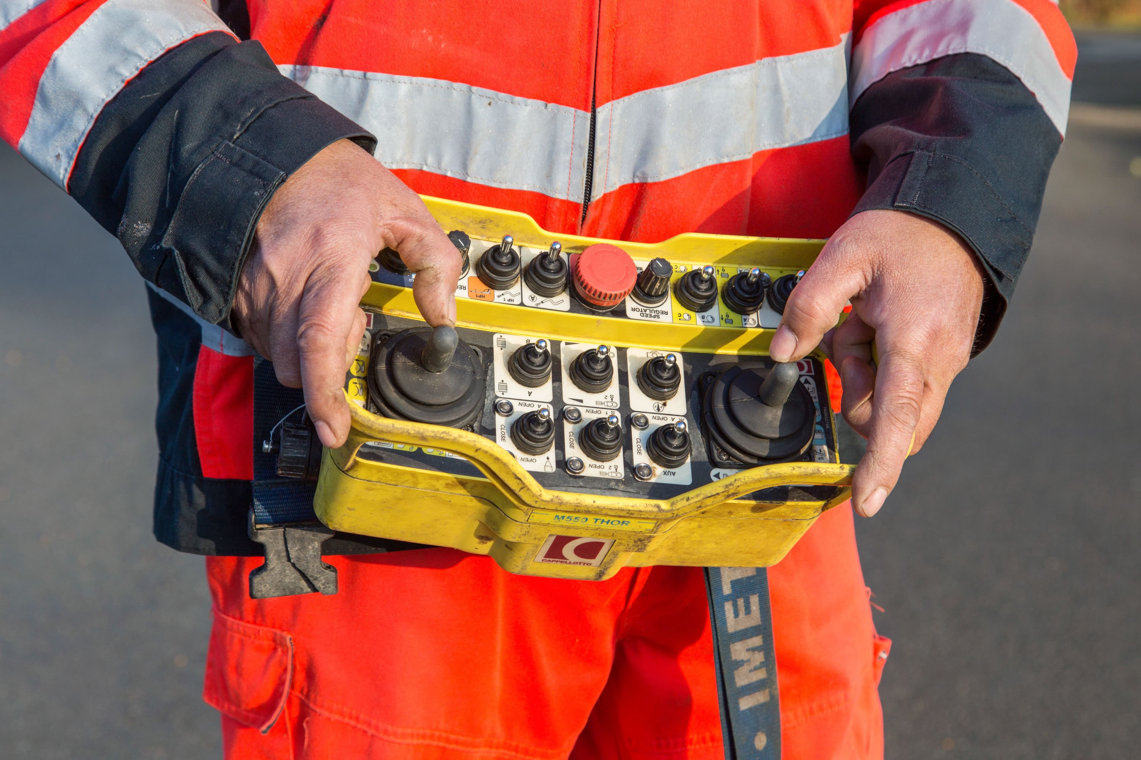 Technicien ABL en Loire-Atlantique tenant une télécommande de diagnostic pour le pilotage d’un camion hydrocureur lors d’une inspection de réseau d’assainissement.