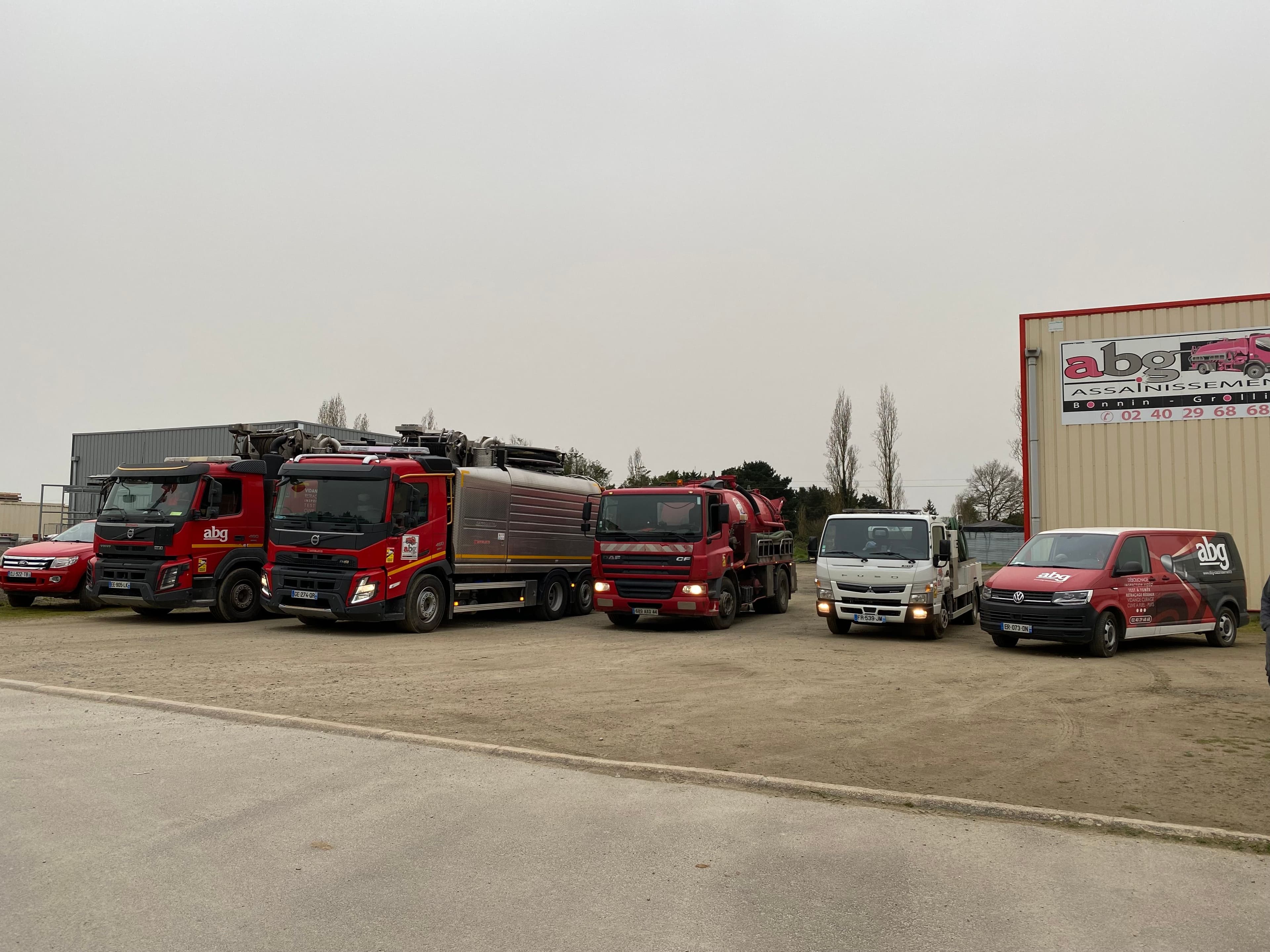 Flotte de camions et vehicules legers ABG Assainissement stationnes devant les locaux de l’entreprise a Nort sur Erdre, specialiste de l’assainissement en Loire Atlantique.